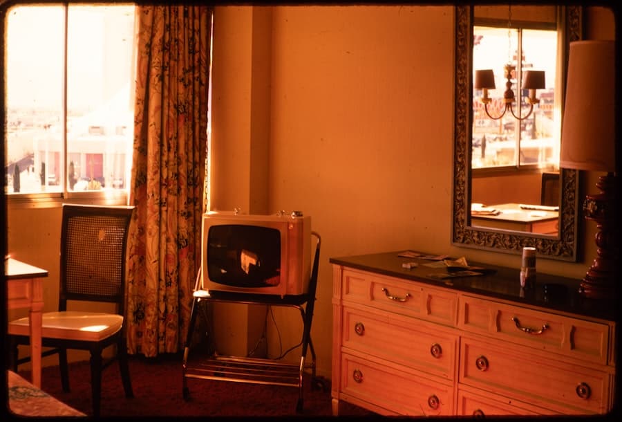 Téléviseur cube rétro posé sur un meuble, dans un intérieur orangé.